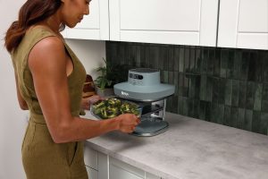Ninja amplia il suo sistema di friggitrici ad aria in vetro con la nuova Ninja CRISPI PRO 9 JPG R AS101UKGY InUse Kitchen Counter ContainerRemove Broccoli Woman